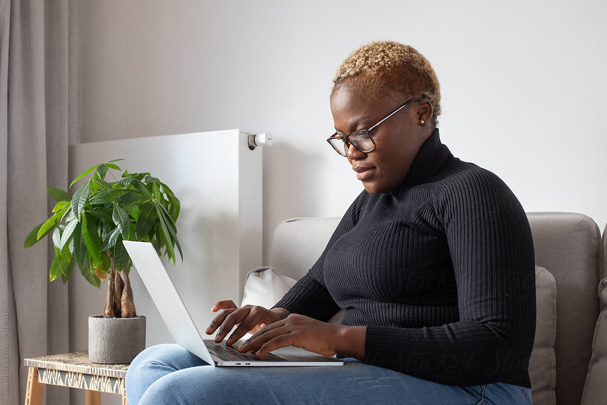 black woman working on laptop computer at home