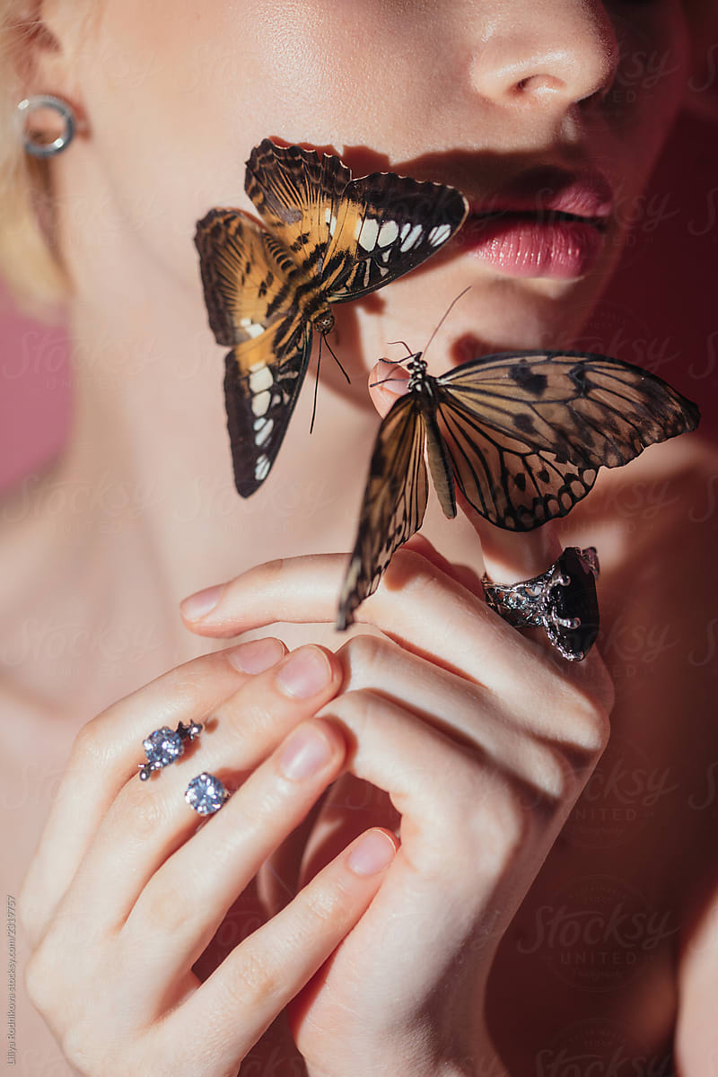 Closeup shot of unrecognizable woman\'s delicate hands and butterflies