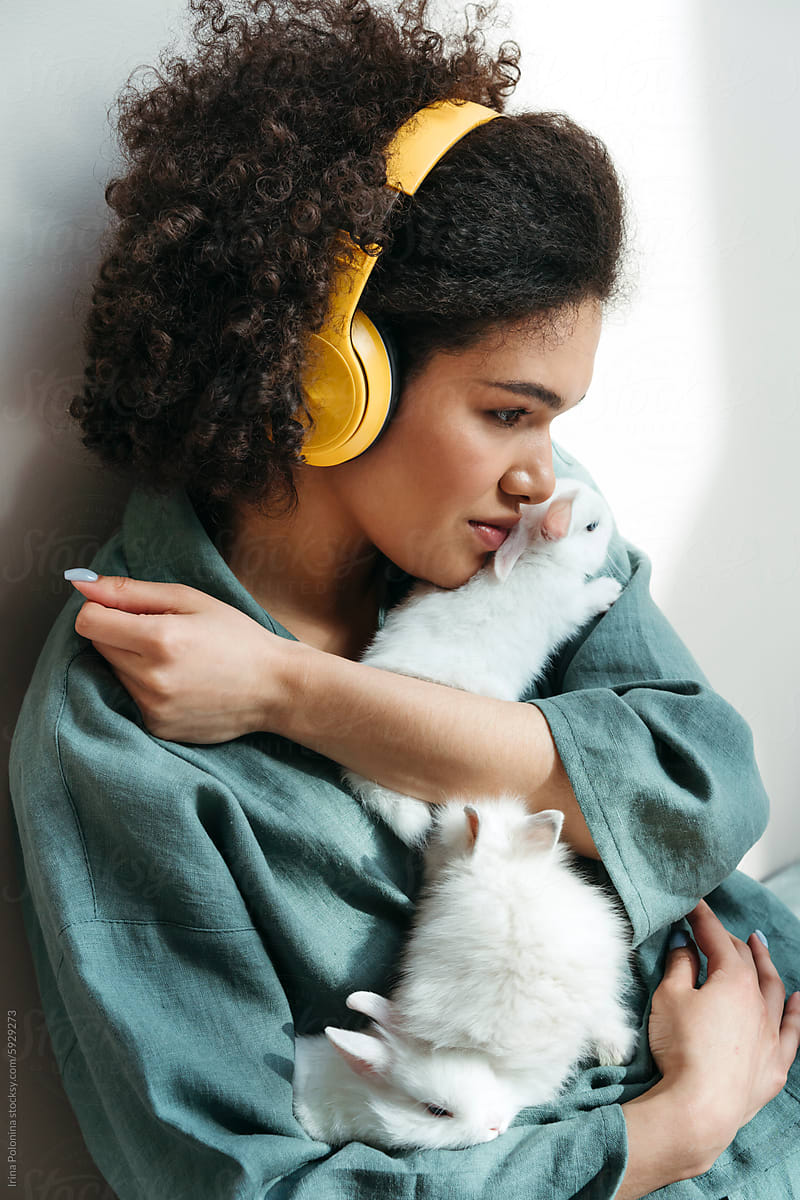 Woman With Headphones Holding White Rabbits