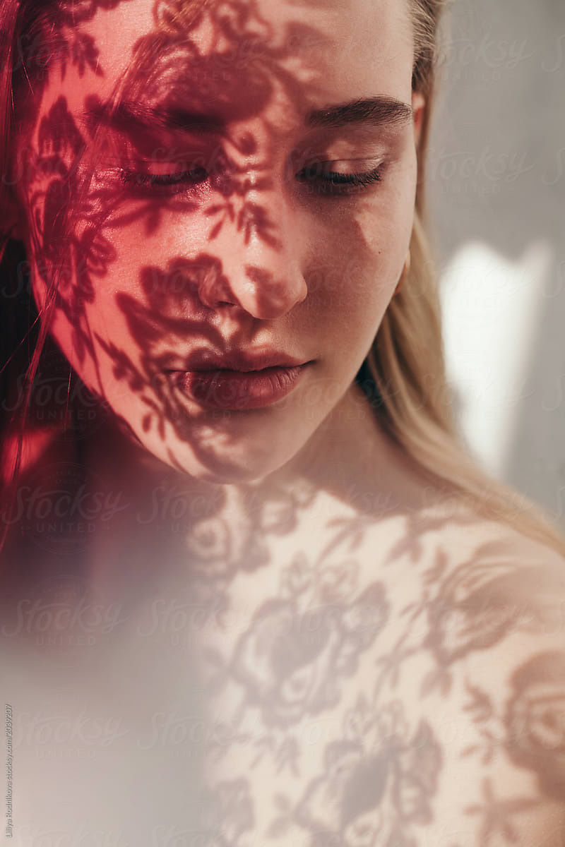 Closeup portrait of amazing girl with floral shadows on her face