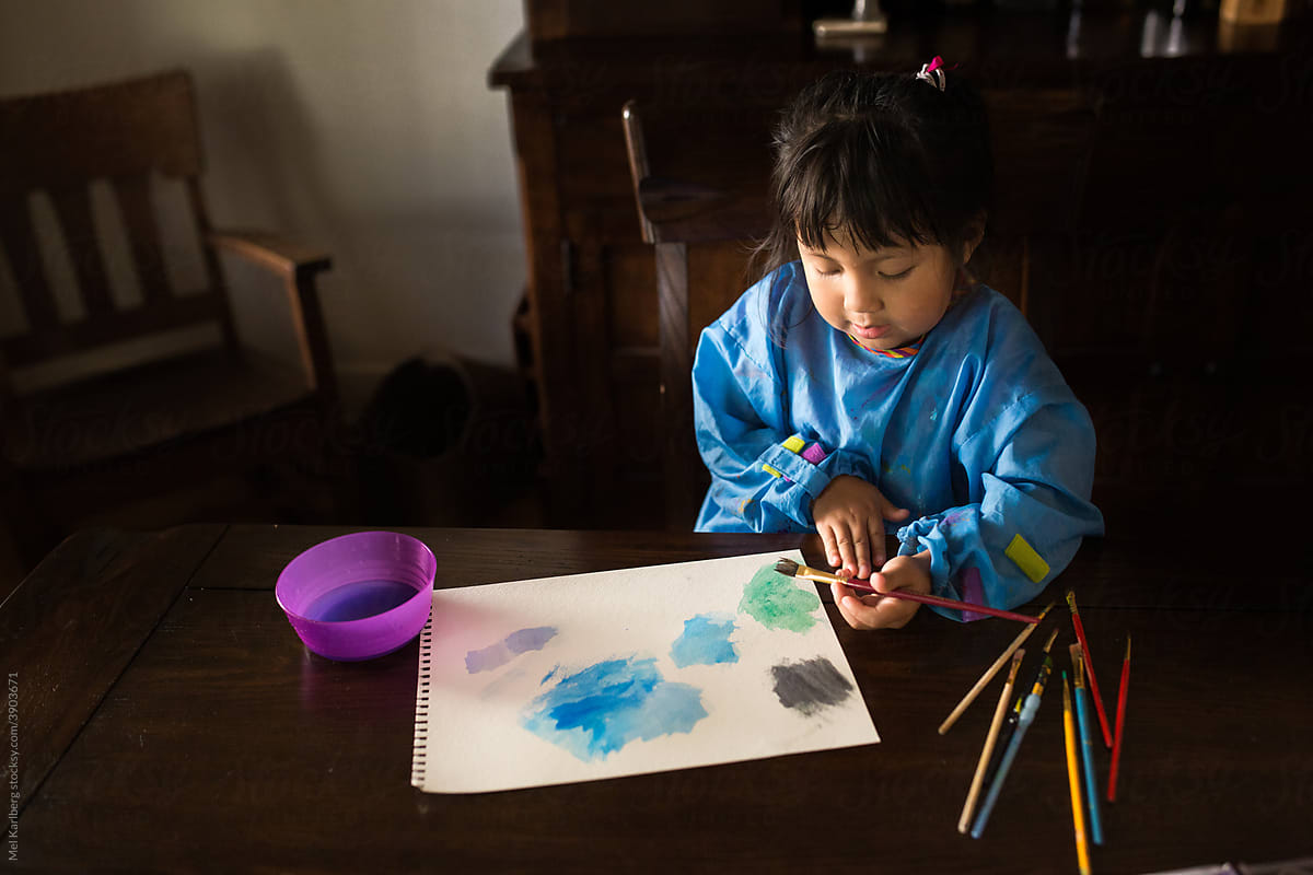 Young girl painting a colorful watercolor picture