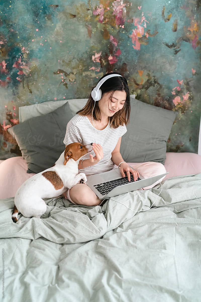 Woman watching movie on laptop at home with dog