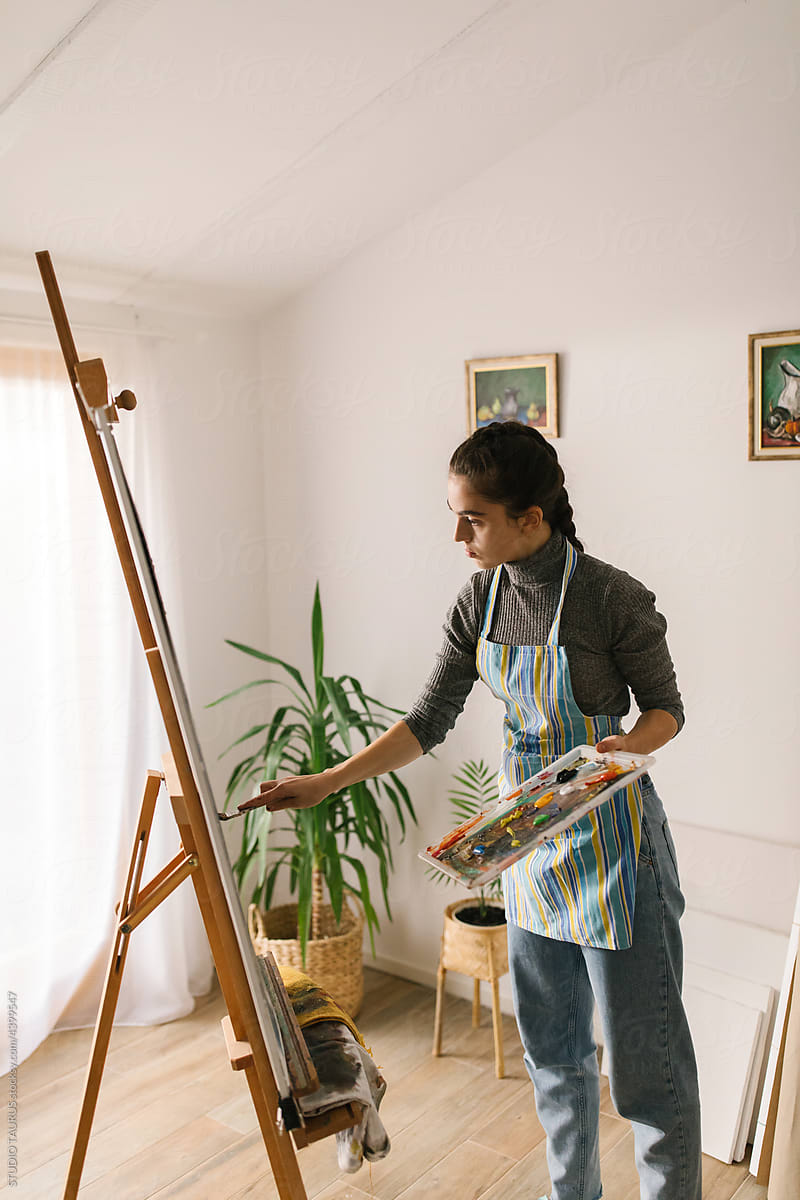 Female artist painting on canvas in art studio