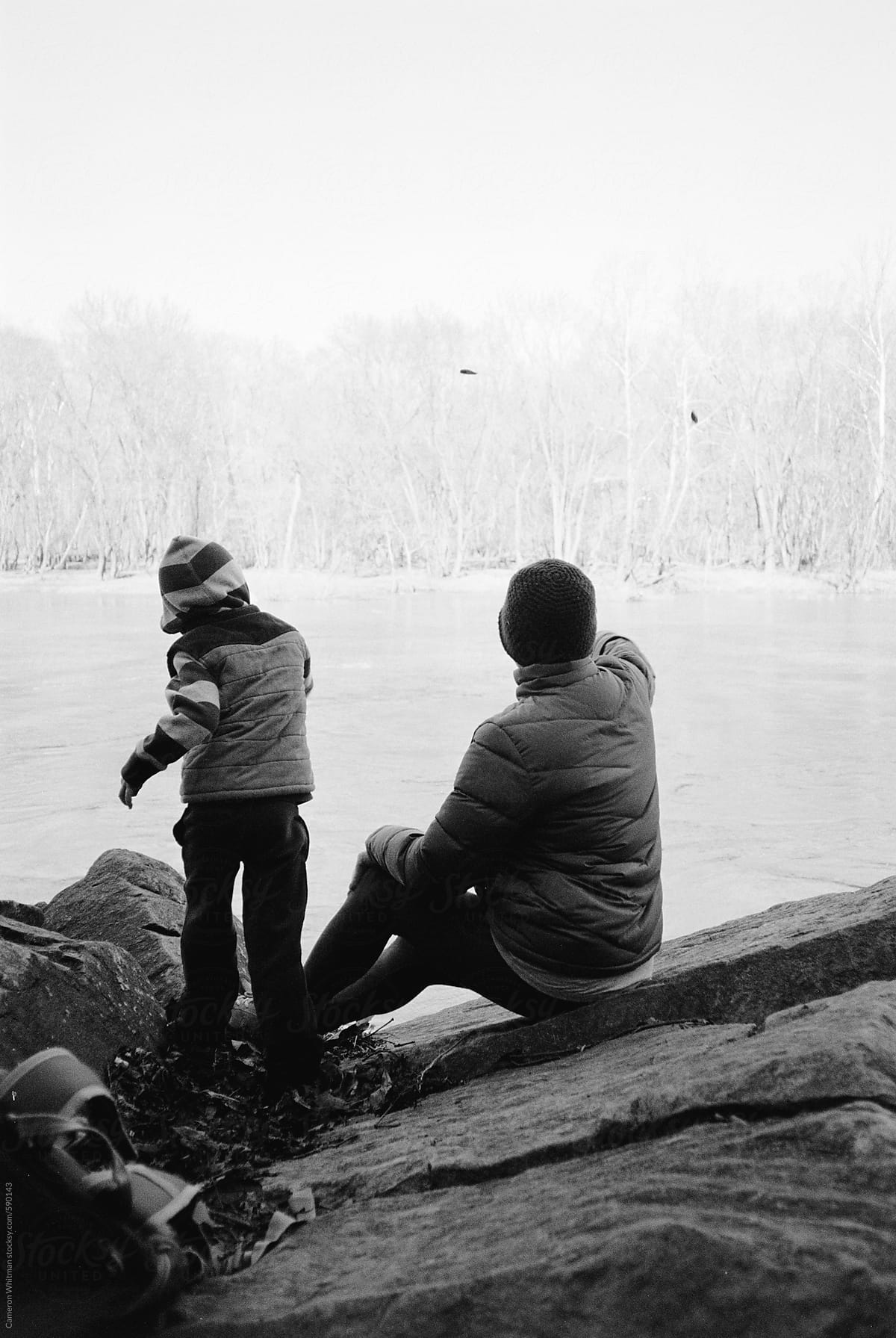 Mother and Son throwing rocks into the river