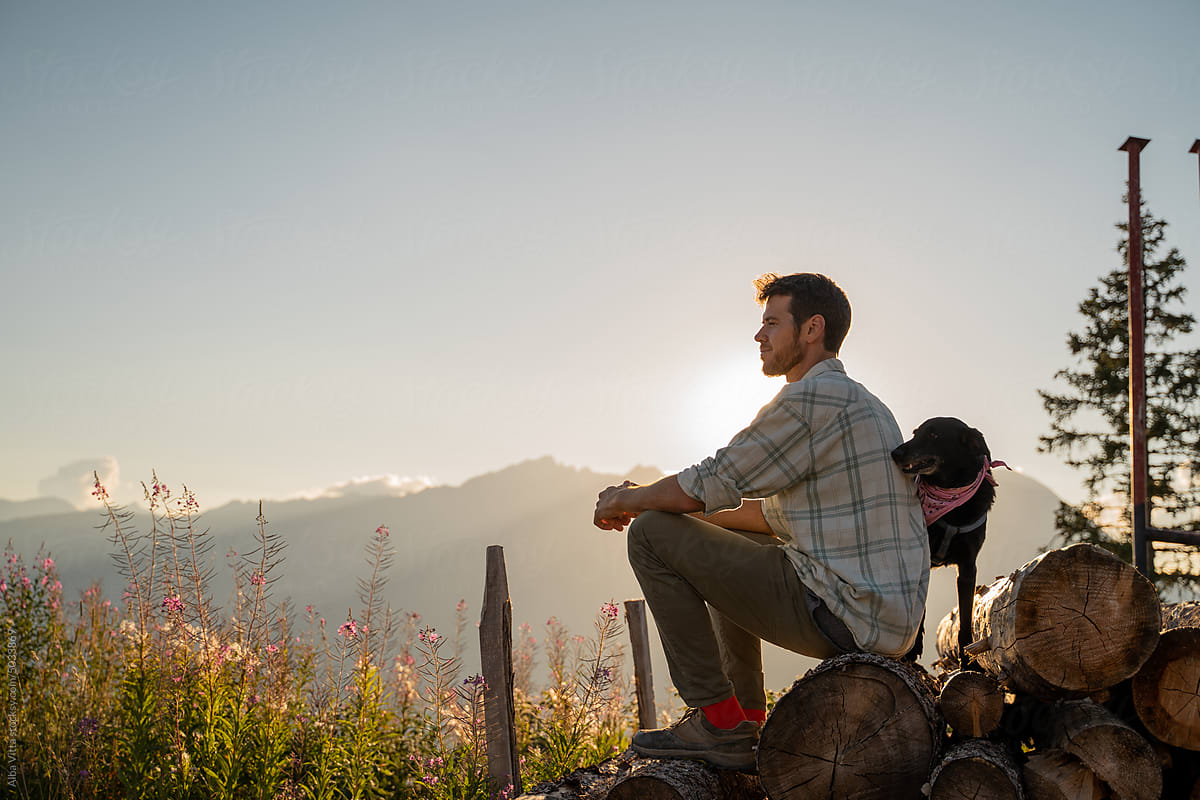 Sunset mountain man portrait with dog
