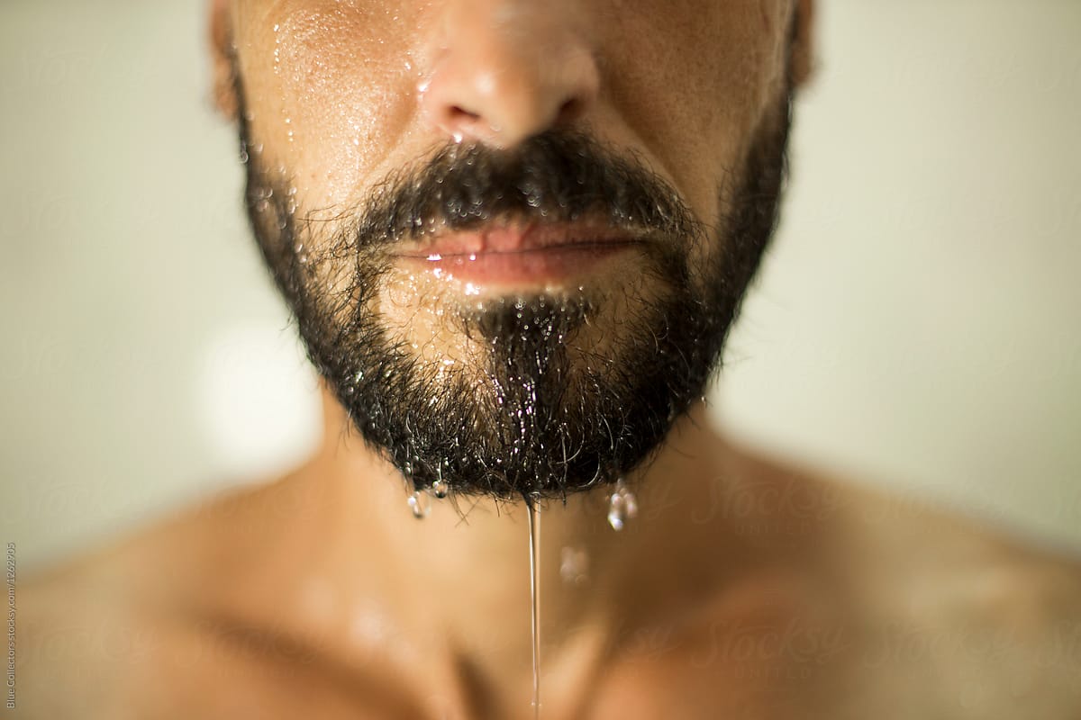 Face of bearded man in shower