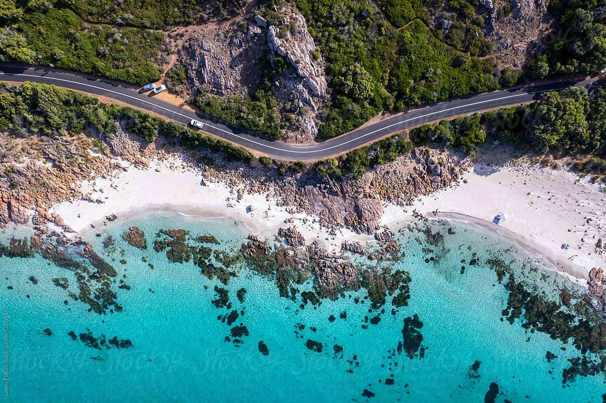 Aerial view of road and crystal clear ocean by the coast