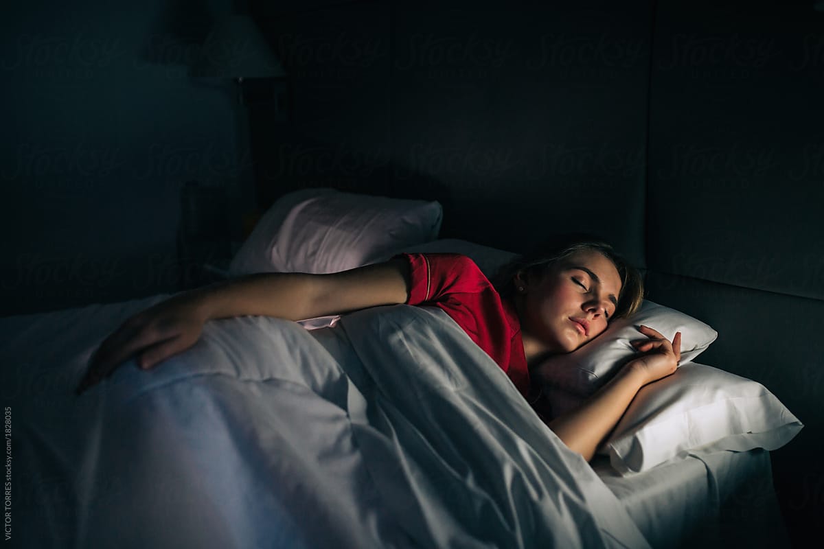 Woman Sleeping At Night With Red Sleepwear by Stocksy Contributor