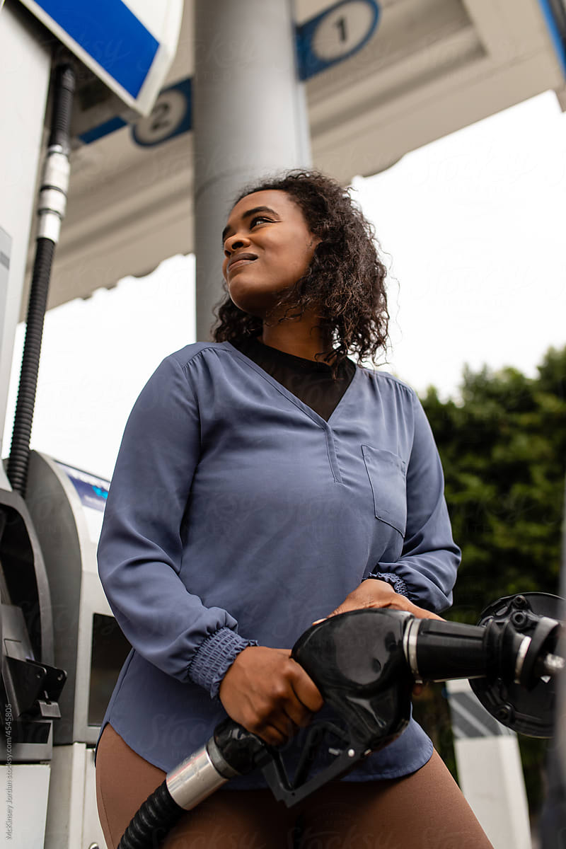 Woman Watches Petrol Meter As She Fills Up Her Car