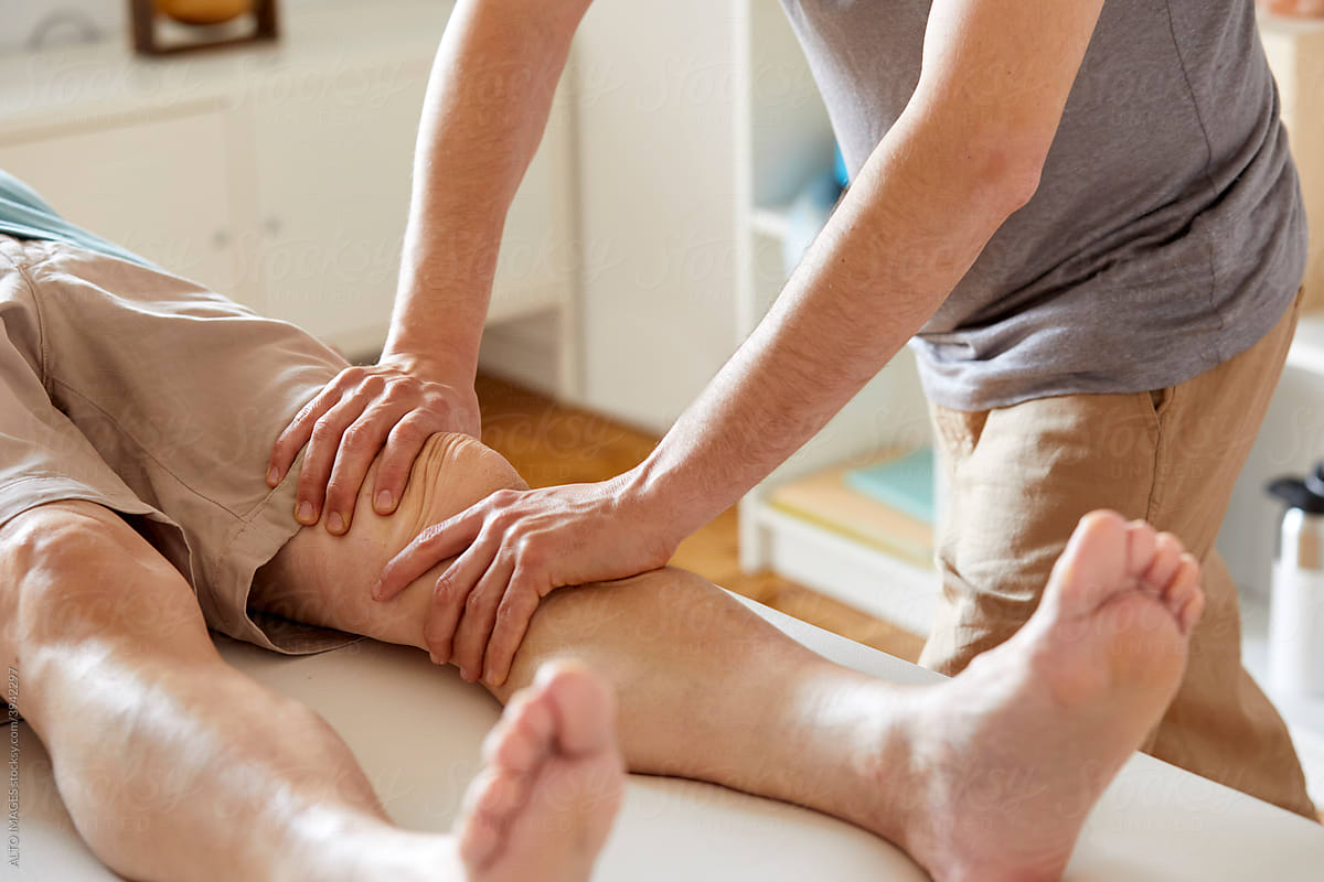 An osteopath applying pressure to patient\'s knee