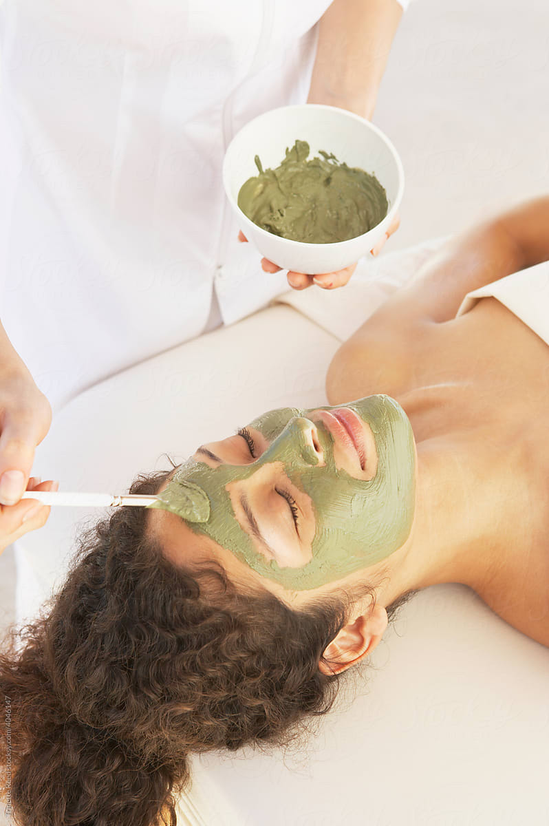 Woman receiving a mud mask facial at luxury spa