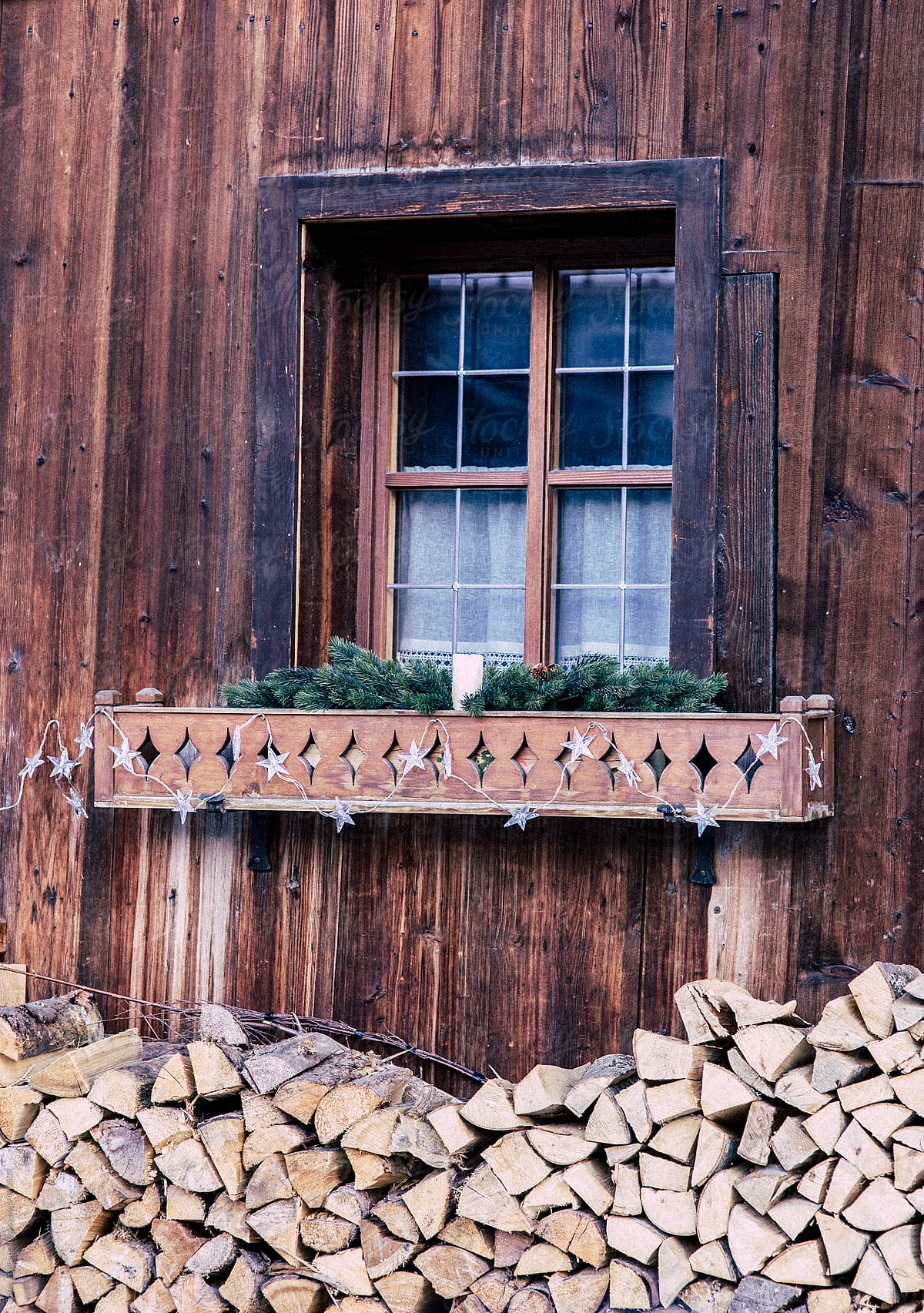Old wooden farm house window with fire wood stacked outside