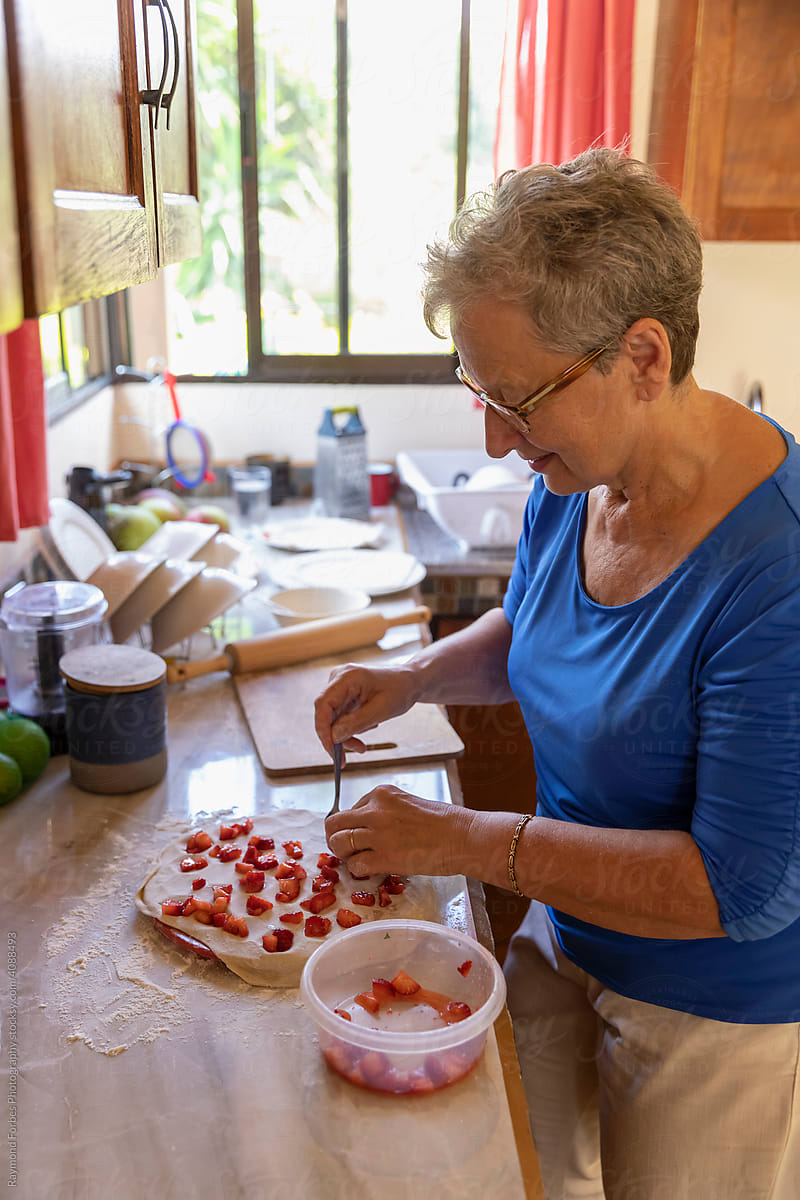 Senior making homemade Palmeni  with  strawberries