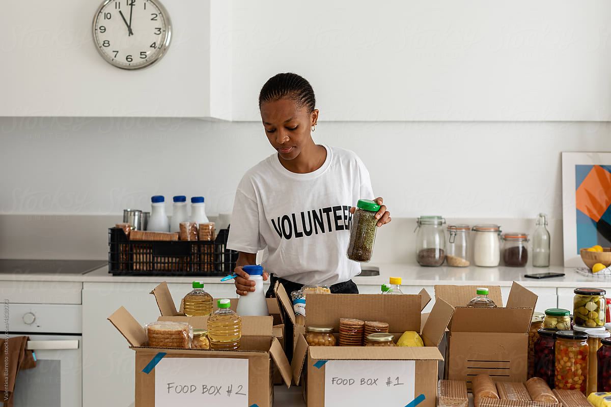 Young volunteer woman preparing food boxes