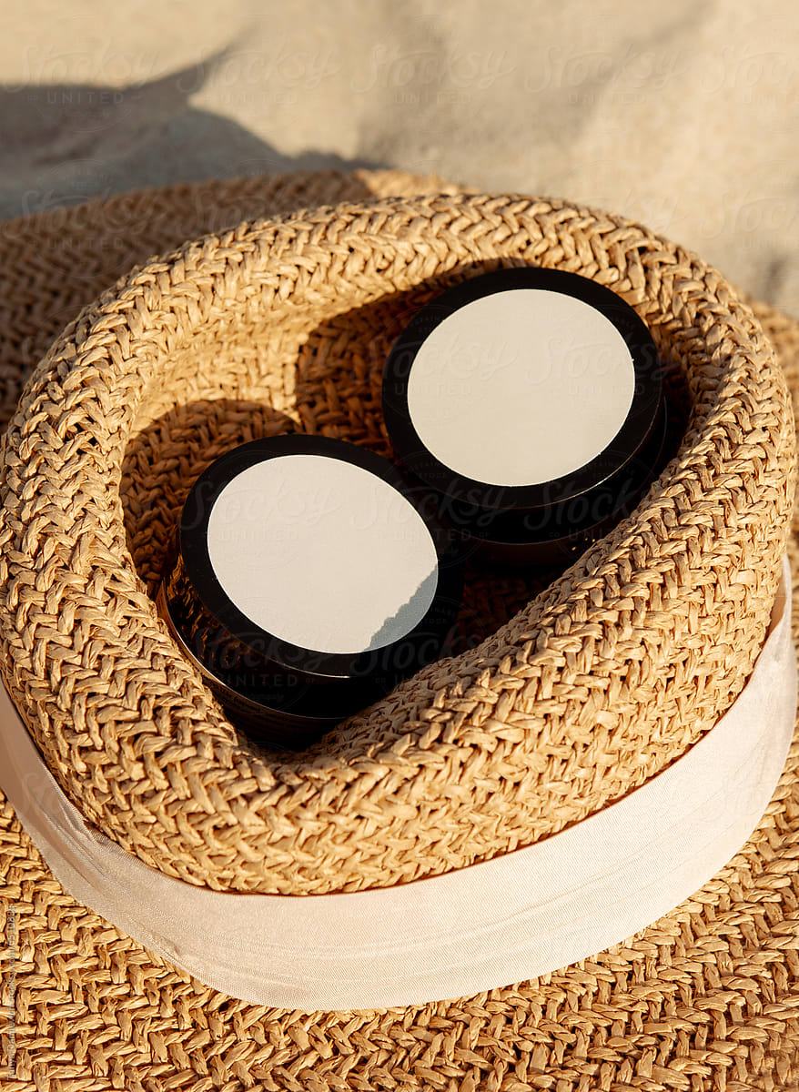 The cosmetic product bottles on the top of straw hat.