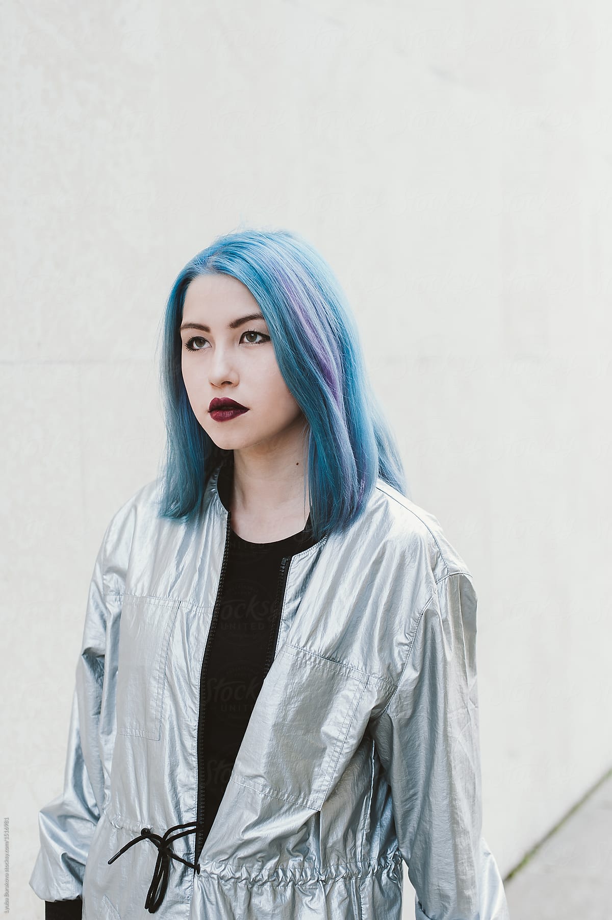 Young woman with blue and lilac hair wearing silver raincoat