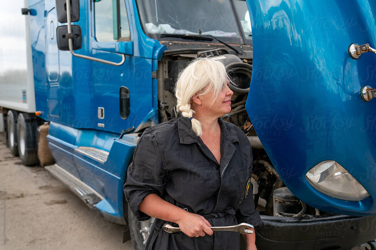 female truck driver preens ar side mirror