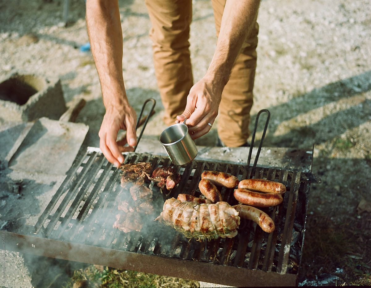 A man making a barbecue and watering meat
