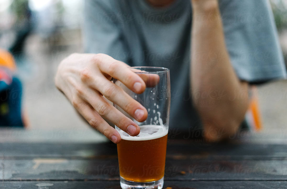 Man holding a glass of beer outside
