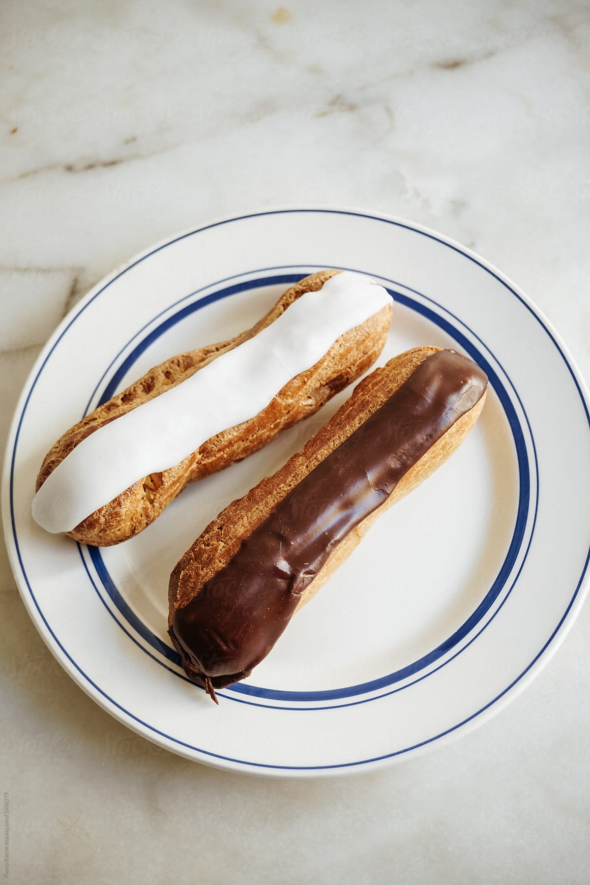 Two eclairs on a plate, ready to be eaten