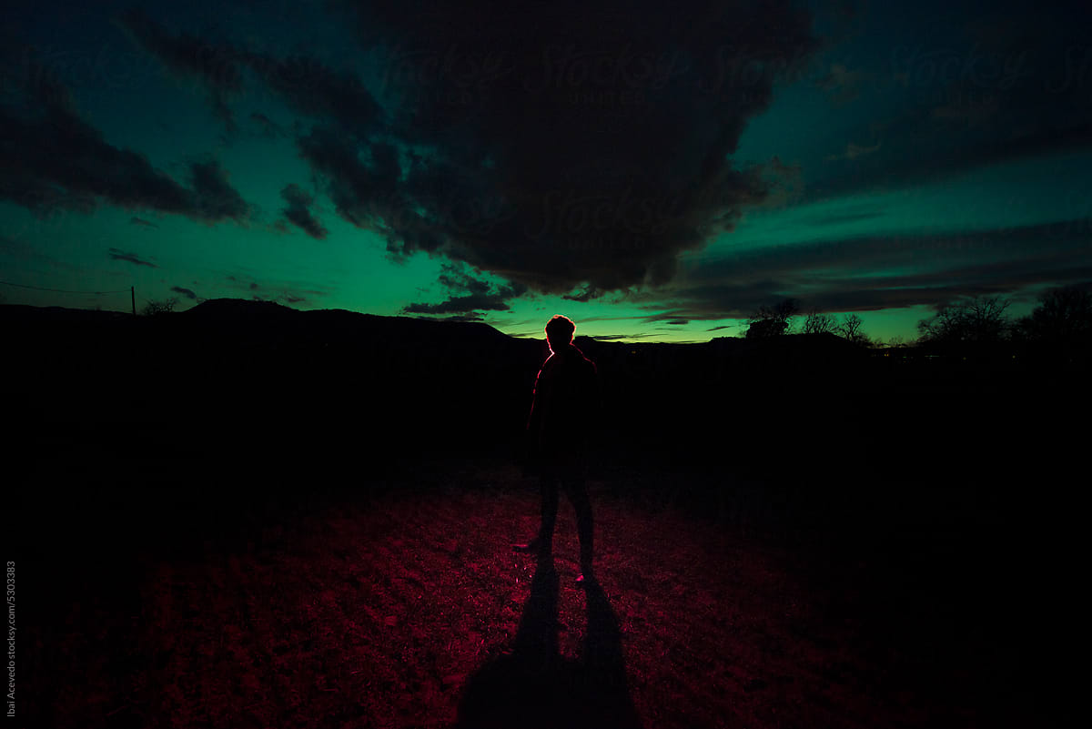 Dark male silhouette standing at surreal scenery