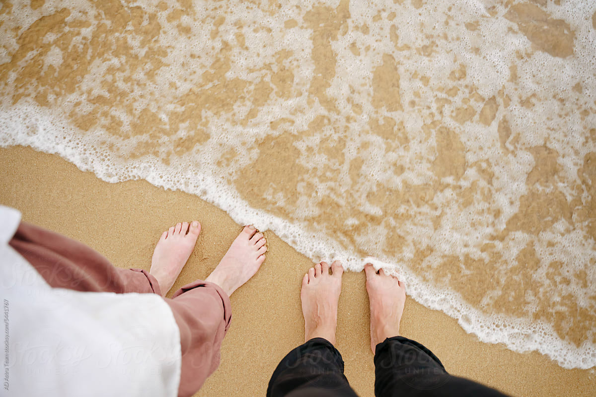 Couple\'s feet on the ocean