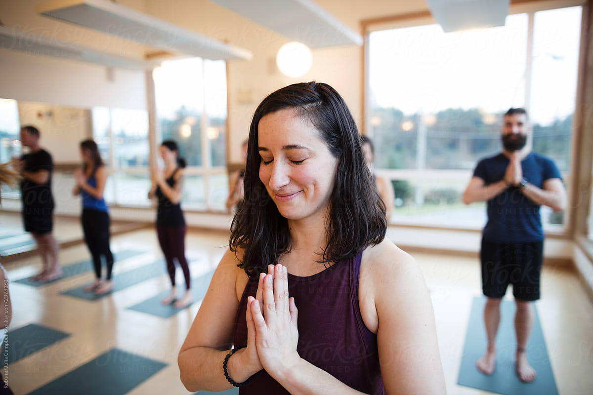 Yoga person in prayer pose in yoga studio class.