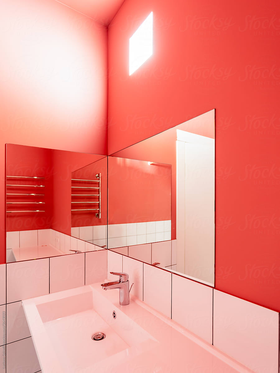 Pink toilet with white sink and two mirrors