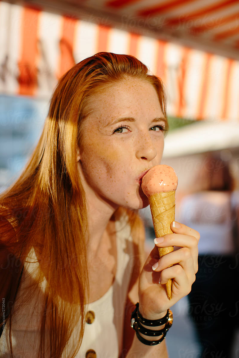 Red-hair woman eating an ice-cream