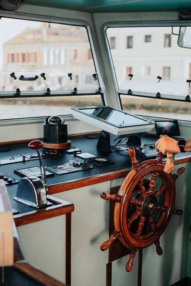 Anonymous hand controls the steering wheel on a ferry boat