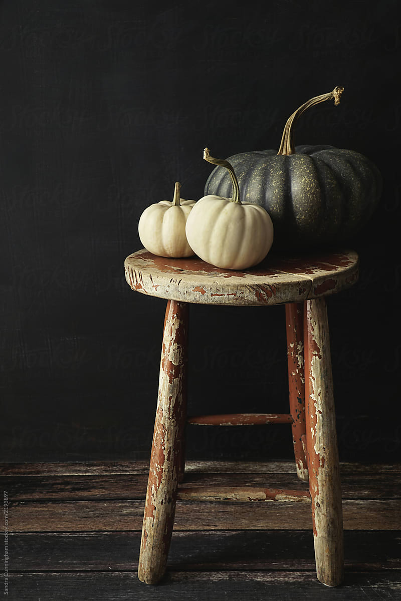 White gourds and pumpkin on old wooden stool