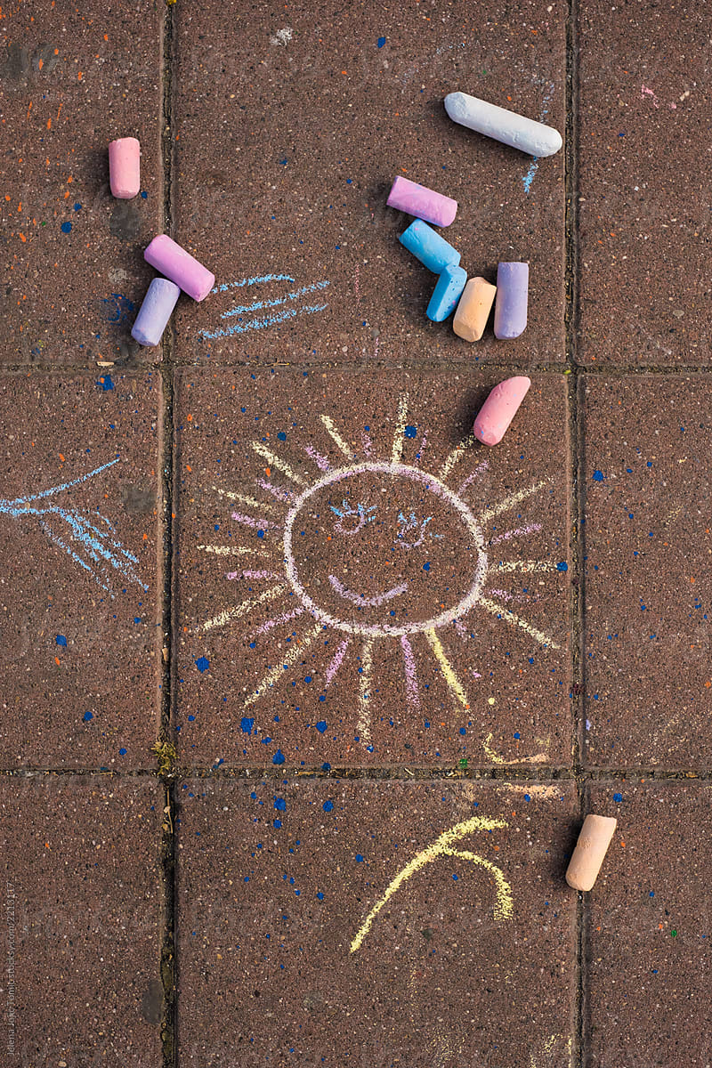 Child chalk drawing of a sun on a pavement