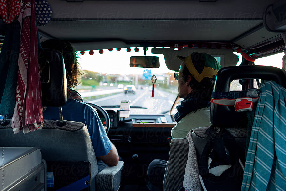 Two traveler guys driving one the highway in their camper van