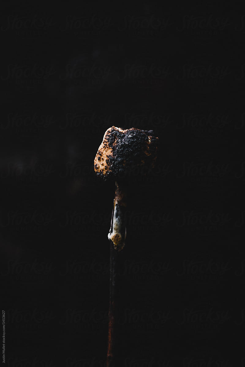 Charred and blackened marshmallow on a stick.