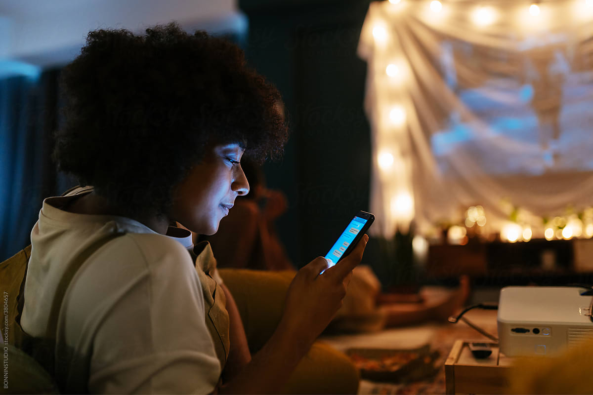 Black woman texting at movie night