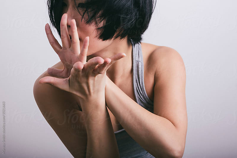 Flexed hands held near the face of a female dancer