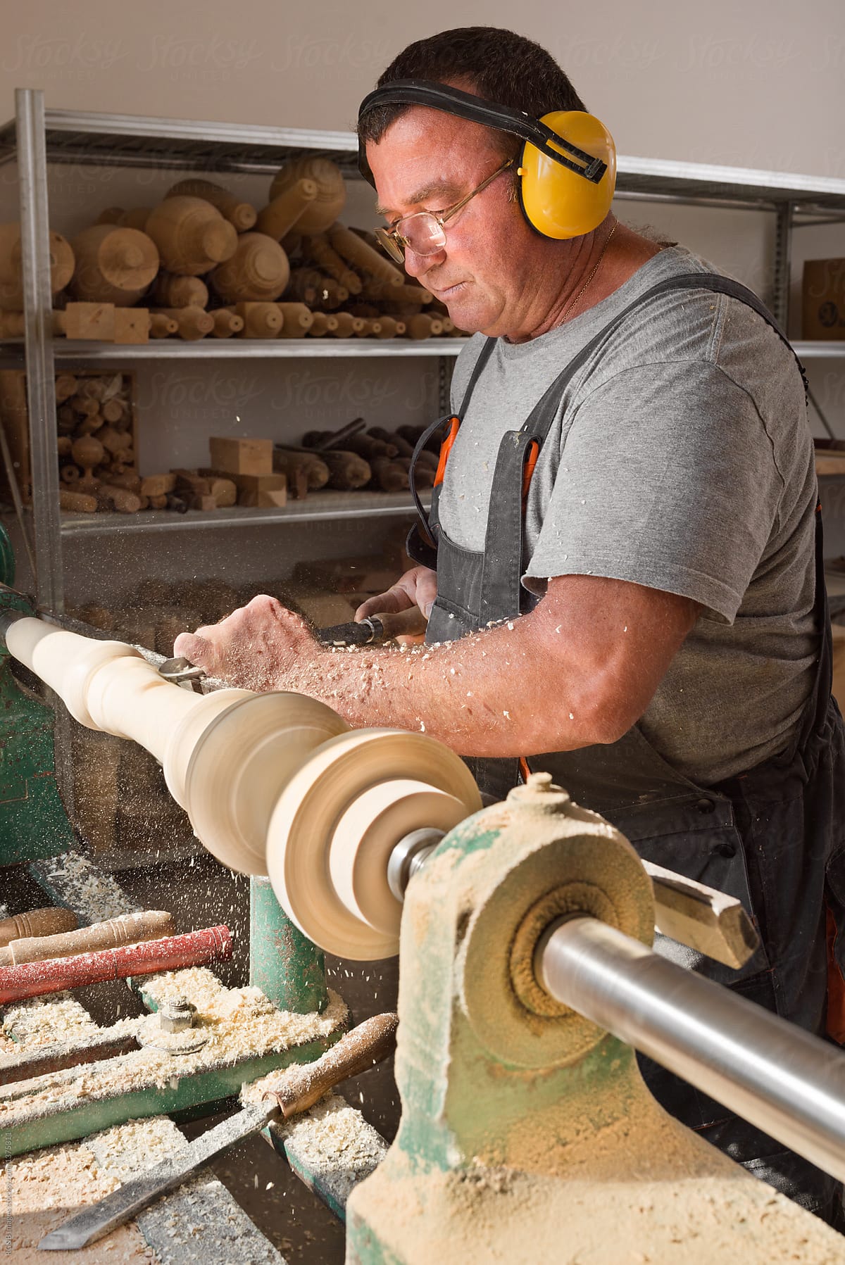 Man working on carpentry lathe in his workshop