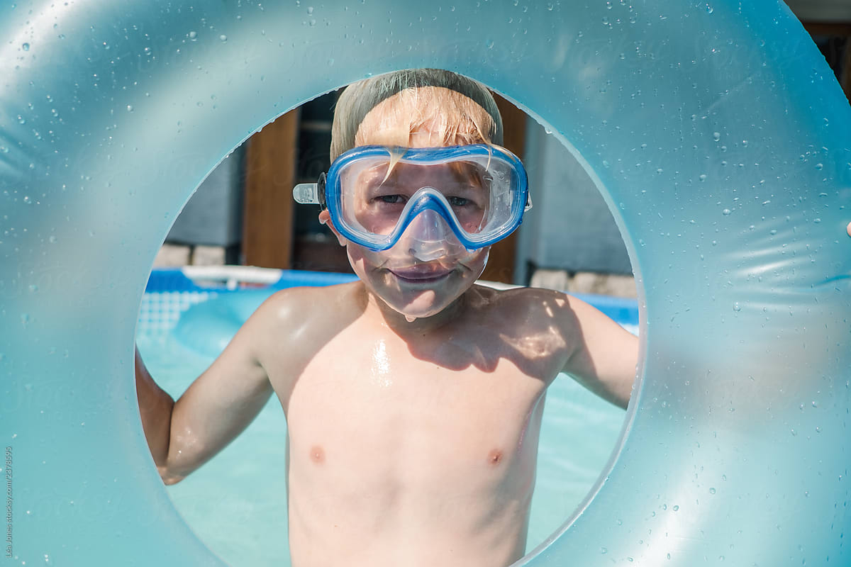 little boy with goggles in a kiddie pool