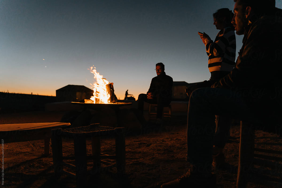 Friends gathering around a bonfire in the desert