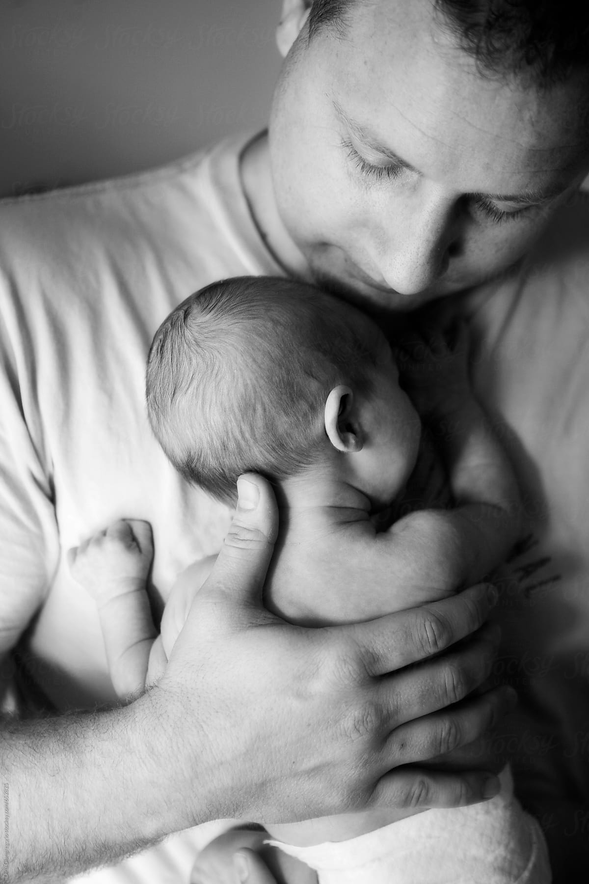 Father Tenderly Holding Newborn