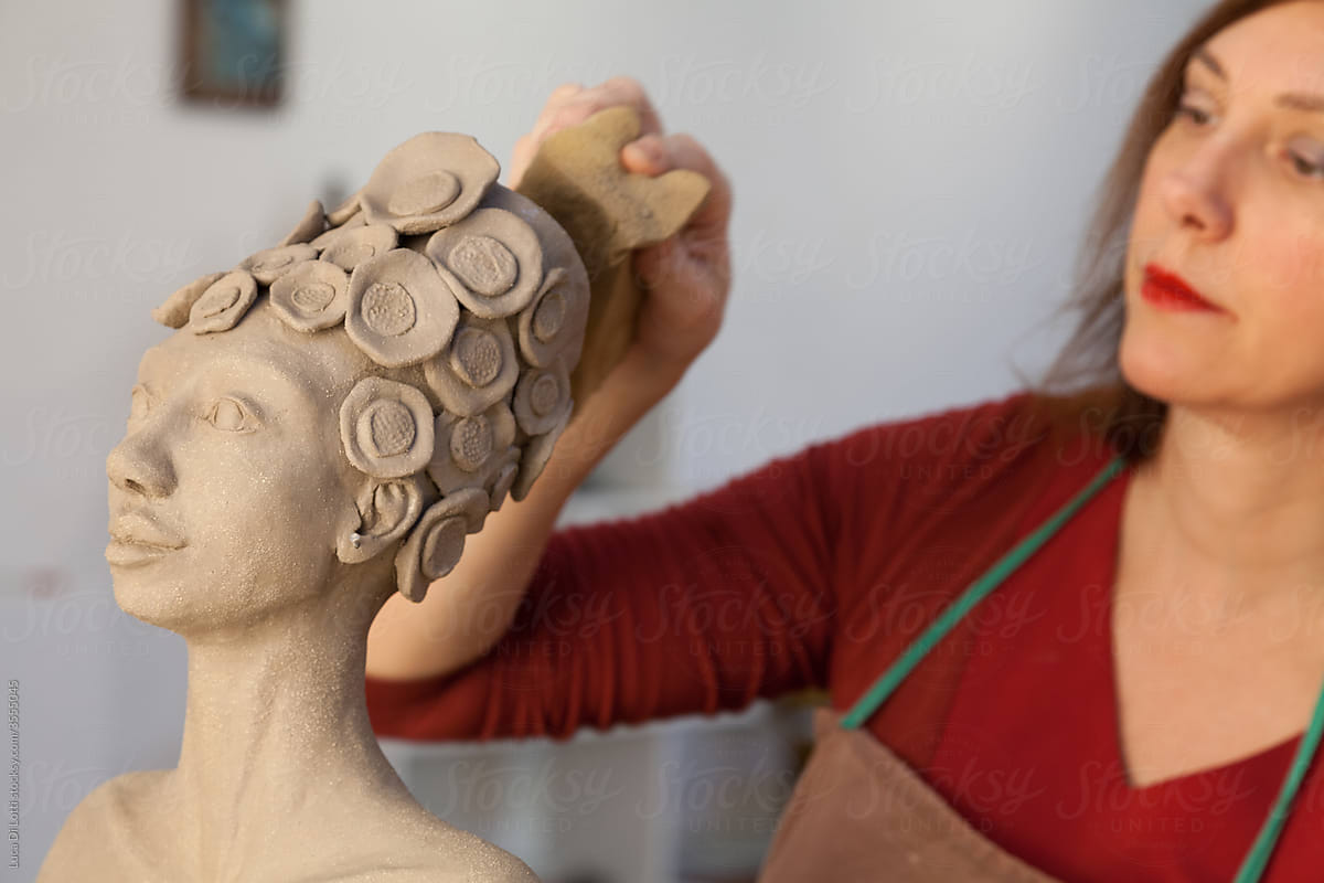 artist working on a statue of clay