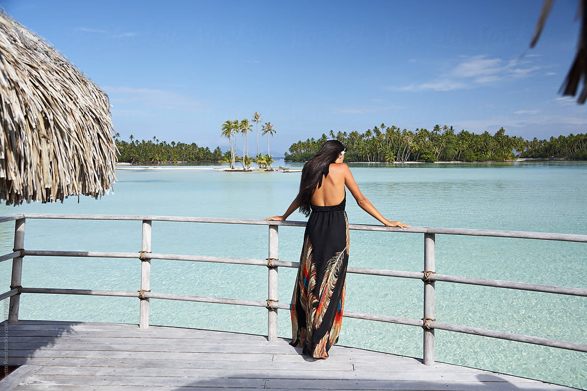 Woman looking at view on deck of overwater bungalow