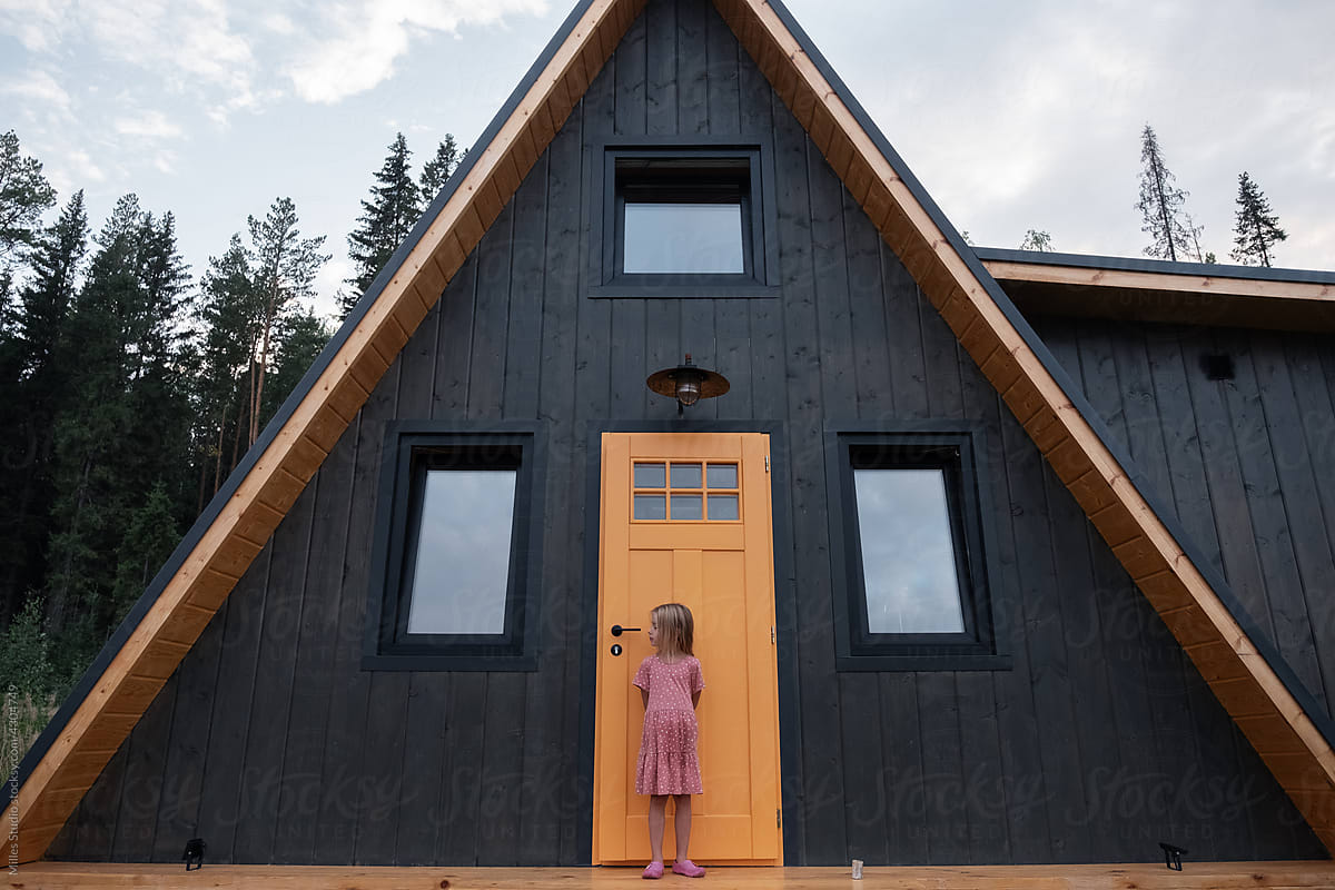 Girl standing near door of countryside cottage