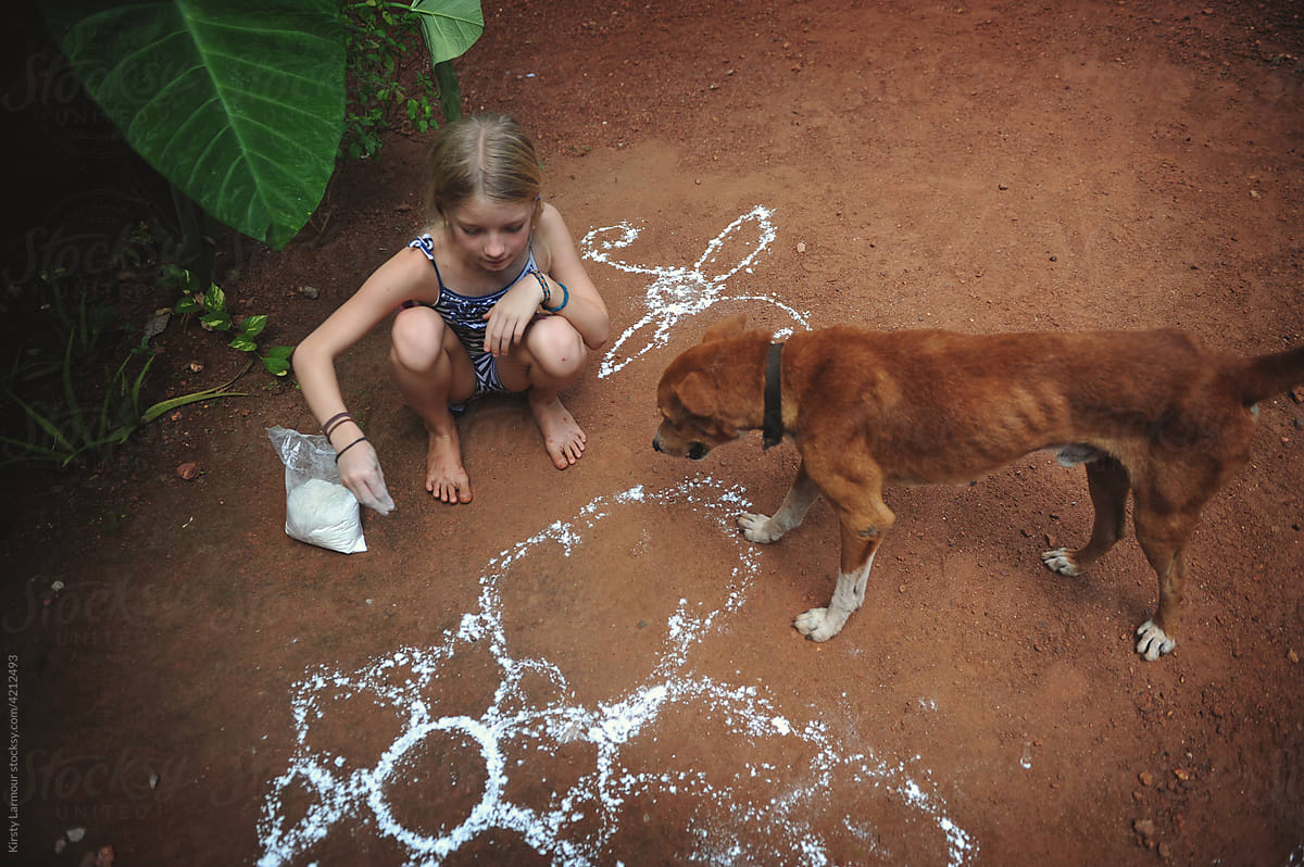 A girl creates a mandala with her dog
