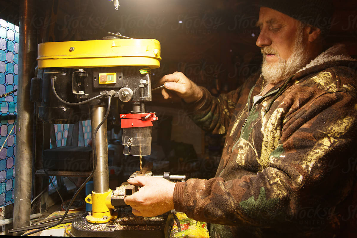 Senior craftsman using drill press
