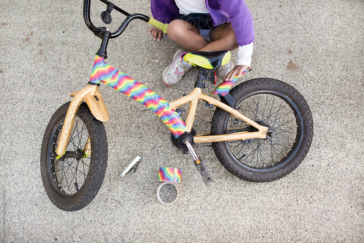 Girl with taped rainbow bike