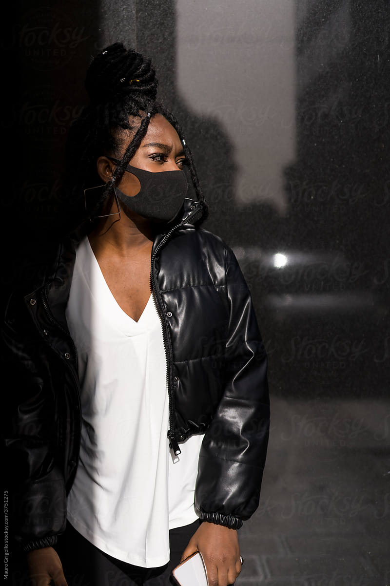 Black woman wearing a surgical mask outdoor