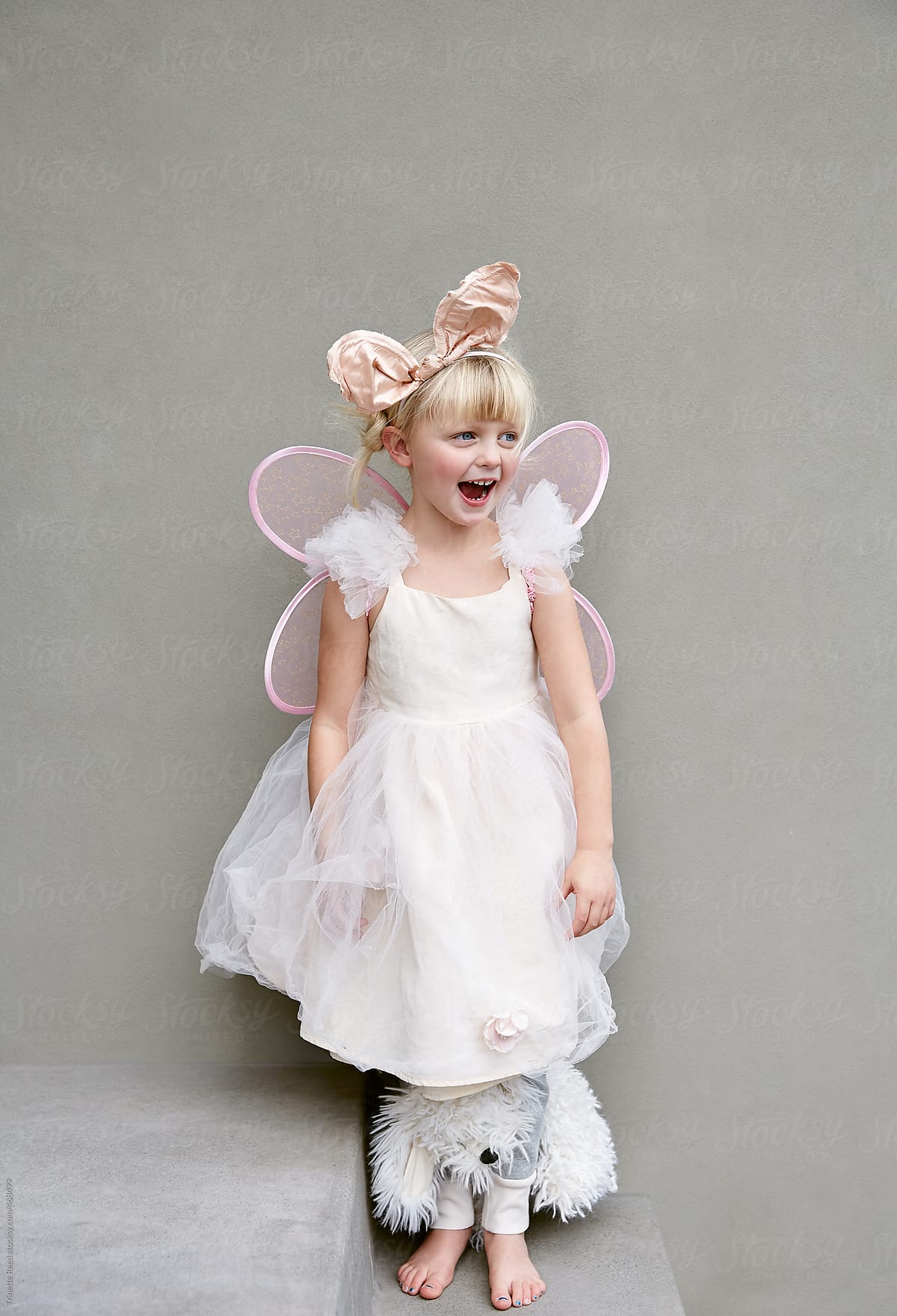 Portrait of surprised cute little girl in angel costume.