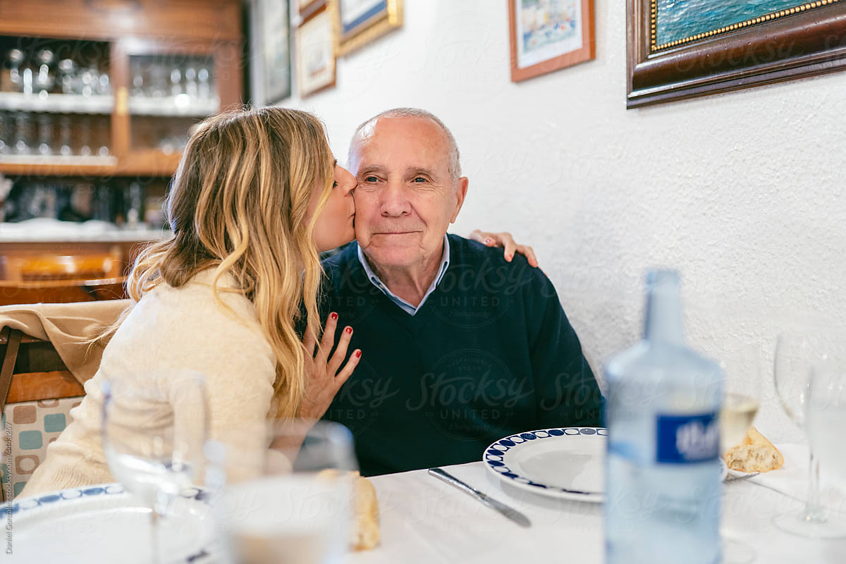 Loving woman kissing senior father in cheek