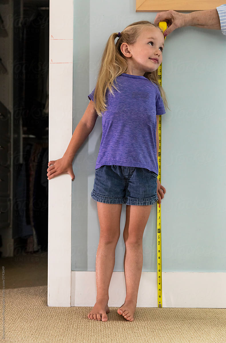 Adorable  Young Girl Measuring her height